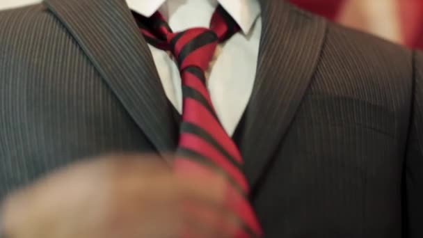 Close-up van jonge man handen als hij zijn das bevestigt — Stockvideo