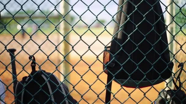 Tassen opknoping van hek binnen dugout op honkbalveld — Stockvideo