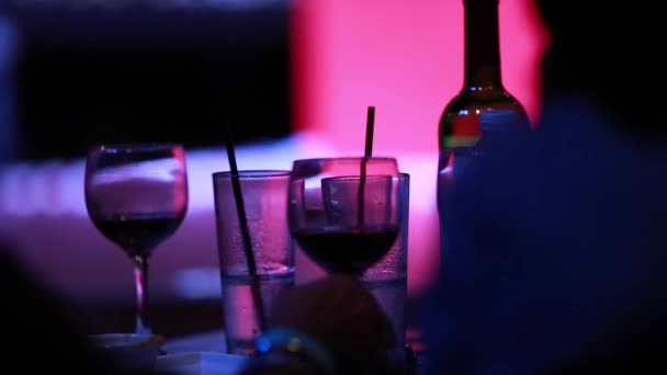 Menschen trinken Wein an Bar mit kühler Beleuchtung. — Stockvideo