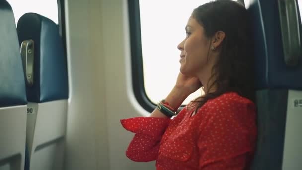 Жінка отримує дзвінок і розмовляє на своїй камері всередині рухомого поїзда — стокове відео