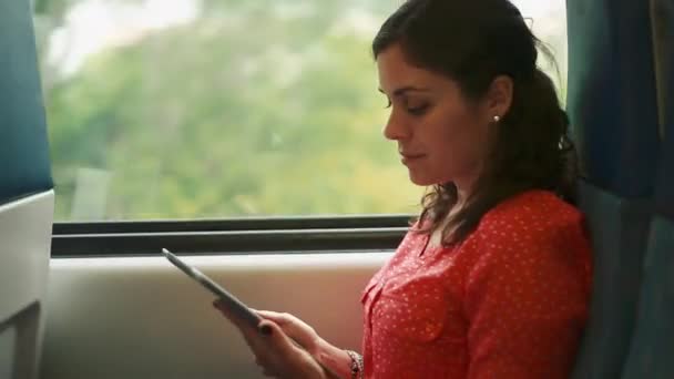 Vrouw met behulp van een tablet in een rijdende trein — Stockvideo