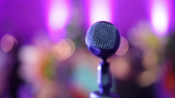 Microphone on a stage with blurred audience in front, taken from stage — Stock Video