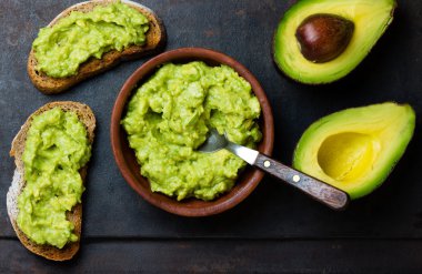 Latin Amerika sos guacamole ve avokado sandviç koyu arka plan üzerinde.