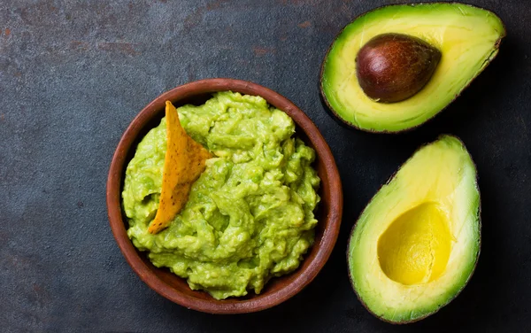 Latin-amerikai mártás guacamole, a avokádó és szendvicsek a sötét háttér. — Stock Fotó