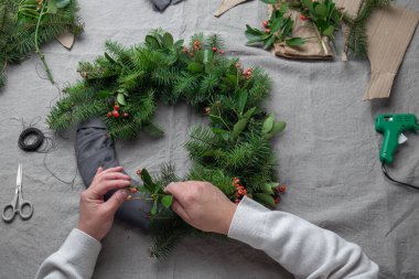 Noel çelengi yapan adam. Yeni yıl tatili dekorasyonu