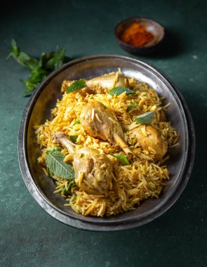 Hint ya da Pakistan yemekleri. Chiken Biryani pirinç birası ve yeşil arka planda naneli bitki ve naan ekmeği.