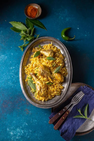 Cibo indiano o pakistano. Biriana di riso Chiken Biryani con erbe alla menta e pane naan su sfondo blu — Foto Stock