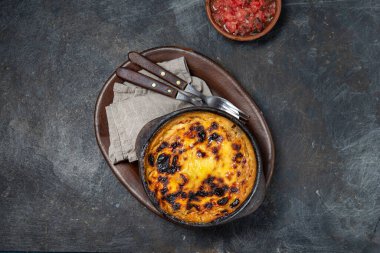 Şili yemeği. Geleneksel Pastel de Choclo mısır turtası. Soğanlı sığır eti, tavuk ve yumurta, kilden kaseyle kaplı mısır, üst görünüm.