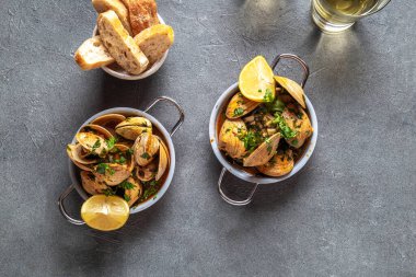 Kişniş, limon ve beyaz şaraplı midyeler gri arka planda küçük tavalar, üst manzara