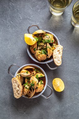 Kişniş, limon ve beyaz şaraplı midyeler gri arka planda küçük tavalar, üst manzara