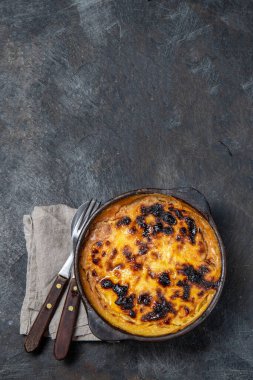 Şili yemeği. Geleneksel Pastel de Choclo mısır turtası. Soğanlı sığır eti, tavuk ve yumurta, kilden kaseyle kaplı mısır, üst görünüm.