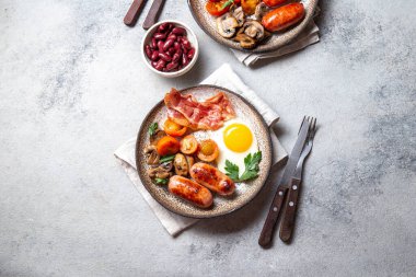 İngiliz kahvaltısı omlet, pastırma, sosis, fasulye, beyaz arka planda tost.