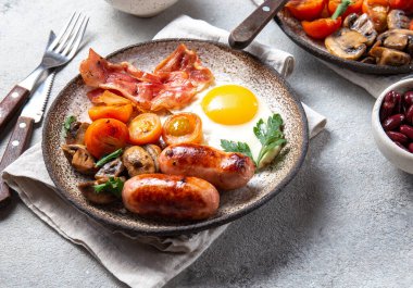 İngiliz kahvaltısı omlet, pastırma, sosis, fasulye, beyaz arka planda tost.