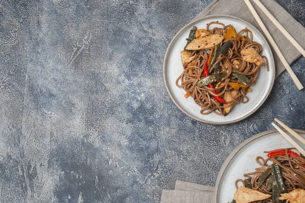 Японское блюдо гречневая соба лапша с курицей и овощами морковь, перец и зеленая фасоль в воке на темно-синем фоне — стоковое фото