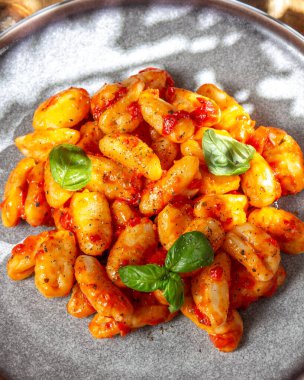 Domates soslu patates gnocchi ve gri tabakta fesleğen. Yüksek kalite fotoğraf