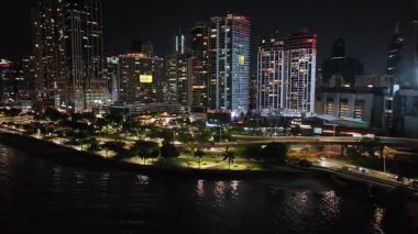 Panama City 'nin gece manzarası. Suya yansıyan ışıklar ve arka planda yüksek binalar. Yüksek kalite 4k görüntü