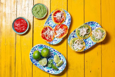 Lezzetli Meksika chalupaları, canlı soslar ve taze limonlarla servis edilir..