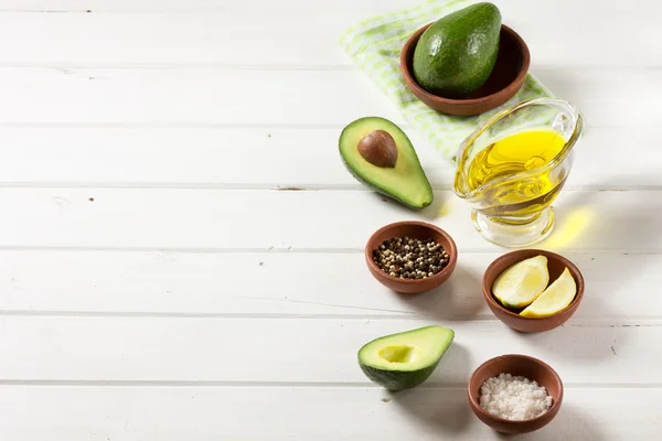 Abacate, e outros ingredientes para guacamole molho na mesa . — Fotografia de Stock