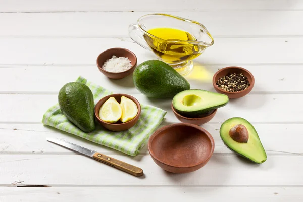 Авокадо и другие ингредиенты для гуакамоле соуса на столе . — стоковое фото