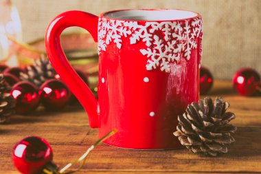 Kırmızı fincan çay ve Noel topları ahşap arka plan üzerinde