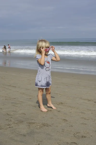 Una niña está jugando en la playa . — Foto de Stock