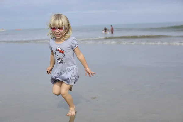 一个小女孩玩在沙滩上. — 图库照片