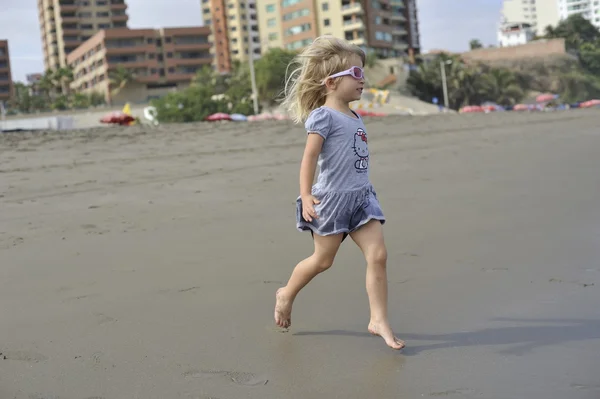 Una niña está jugando en la playa . — Foto de Stock