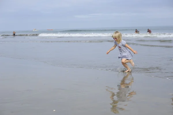 Küçük bir kız sahilde oynuyor. — Stok fotoğraf