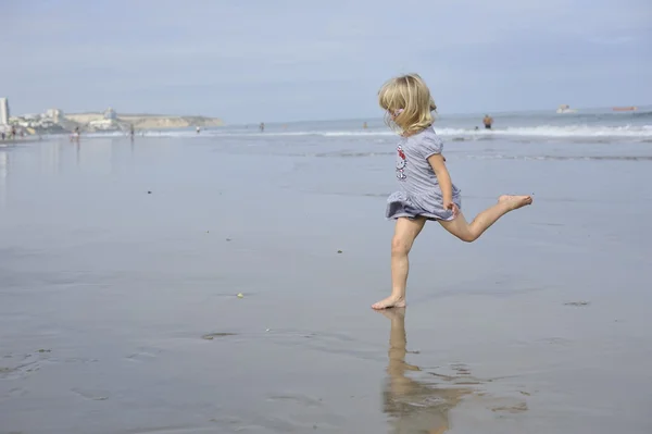 Una niña está jugando en la playa . — Foto de Stock