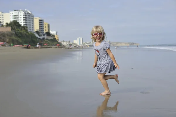 Una niña está jugando en la playa . — Foto de Stock