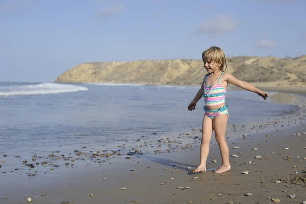 Una niña está jugando en la playa . — Foto de Stock