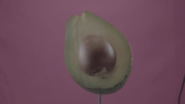 Avocado rotiert mit Schlaufe auf Fuchsia-Bildschirm für Chroma-Taste — Stockvideo