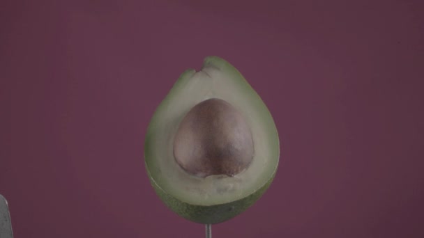 Avocado roteren met lus op fuchsia scherm voor chroma toets — Stockvideo