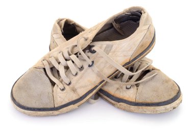 Bir çift çok eski, kirli ve yıpranmış spor ayakkabısı. Delikleri ve yıpranmış kenarları olan, beyaz bir stüdyo arka planında izole edilmiş..