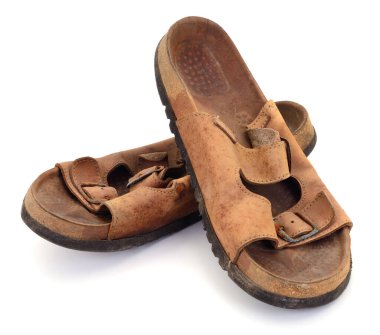 Bir çift eski, kirli ve yıpranmış kahverengi deri sandaletler beyaz arka planda izole edilmiş tokalar. Kullanılan klasik ayakkabı konsepti.