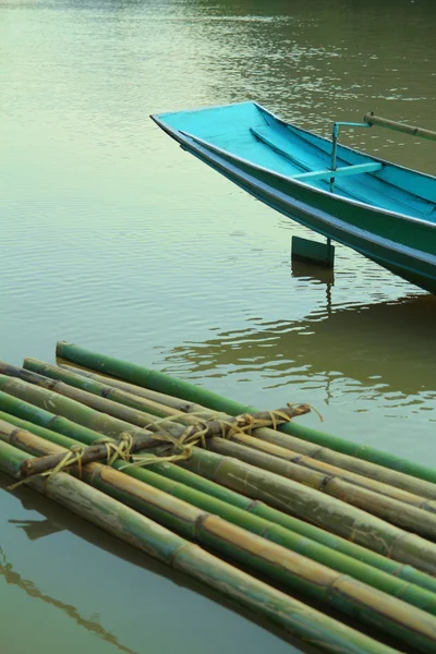 Bote de bambu e barco azul na água — Fotografia de Stock