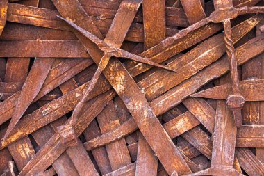 rusty sword, background of a large number of vintage, deformed swords, erosion of blades that once served as weapons, close-up 
