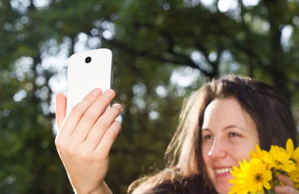 Ung kvinna med vit kamera gör en selfie i höstsäsongen i — Stockfoto