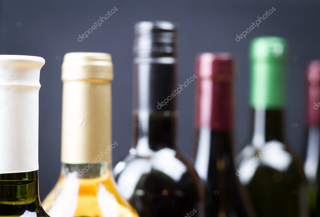 Wine bottles in a row isolated on a gray background