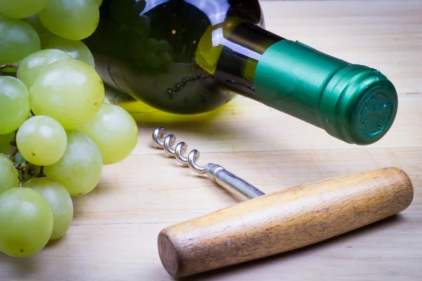 Bottle of white sweet wine with fresh grapes  on the wooden old table
