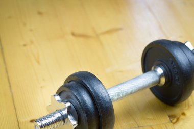 Büyük salonunda ahşap zemin üzerinde büyük siyah dumbells / fitness; spor