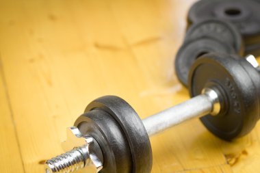 Büyük salonunda ahşap zemin üzerinde büyük siyah dumbells / fitness; spor