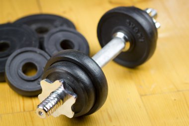 Büyük salonunda ahşap zemin üzerinde büyük siyah dumbells / fitness; spor