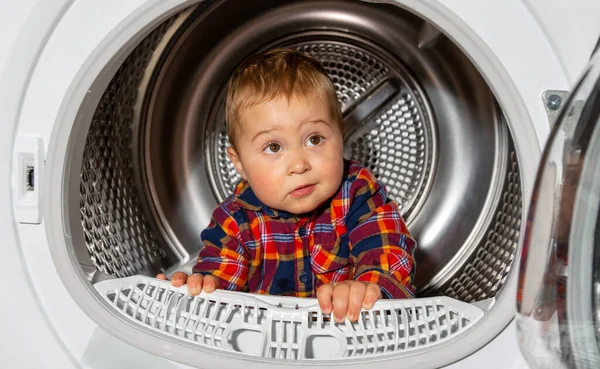 Обложка портрета милого малыша, выглядывающего из стиральной машины, смешная концепция — стоковое фото