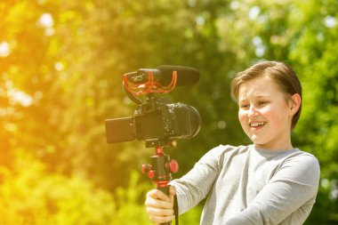 Genç vlogger dışarıda video kaydediyor, videoyu internette paylaşıyor.
