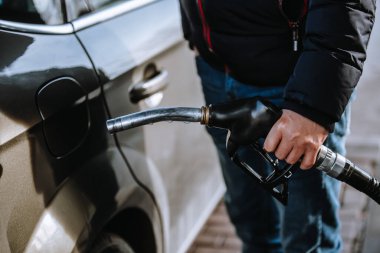 Man preparing to refuel a car in the gas station, refueling the car