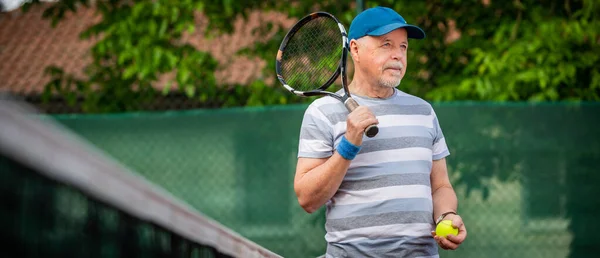 Porträtt av en aktiv senior man som spelar tennis utanför, passar pensionär — Stockfoto