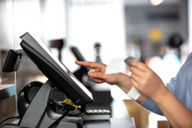 Dükkandaki POS nakit terminalinin fatura ya da fatura ile işlem ödemesi yapan genç kadın, finans kavramı