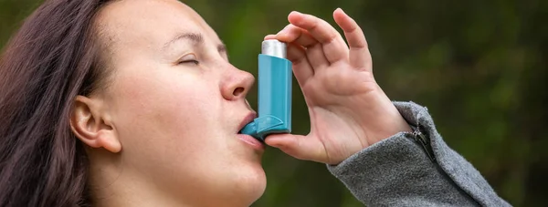 Mujer morena bastante joven que usa inhalador de asma durante un fuerte ataque de asma, el producto farmacéutico se utiliza para prevenir y tratar las sibilancias y la falta de aliento, el concepto de salud — Foto de Stock