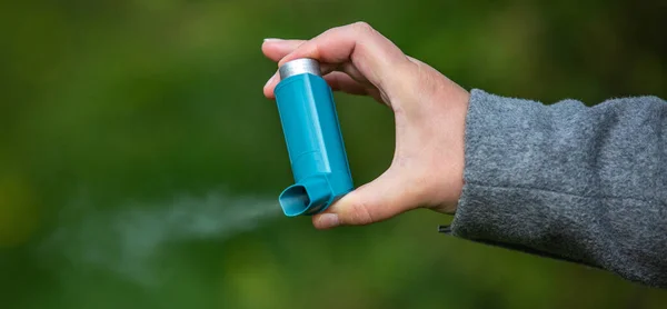 Mujer joven sosteniendo un inhalador de astma contra ataques en sus manos, concepto de salud — Foto de Stock